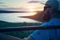 Man with paddle and SUP board near lake at sunset Royalty Free Stock Photo