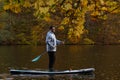 Man Paddleboarding in Autumn Lake Royalty Free Stock Photo
