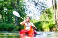 Man paddling with canoe on forest river Royalty Free Stock Photo