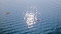 Man paddling single red kayak on blue lake sunny day Royalty Free Stock Photo