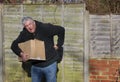 Man in pain carrying heavy box. Back strain. Royalty Free Stock Photo