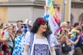 A man in with painted face and blue and white squares and a drag queen attending the Gay Pride in Munich