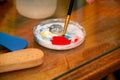 Man painter is mixing colors before painting at art paint studio. Artist in his hand holding paintbrush mixed color oil paints. Royalty Free Stock Photo