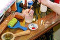 Man painter is mixing colors before painting at art paint studio. Artist in his hand holding paintbrush mixed color oil paints. Royalty Free Stock Photo