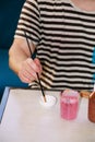 Man painter is mixing colors before painting at art paint studio. Artist in his hand holding paintbrush mixed color oil paints. Royalty Free Stock Photo