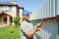 Man painting the fence. Recolor the surface. Summer outdoor activity. Repair background.