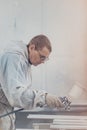 Man painting furniture details. Worker using spray gun. Royalty Free Stock Photo