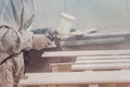 Man painting furniture details. Worker using spray gun.