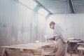 Man painting furniture details. Worker using spray gun. Royalty Free Stock Photo