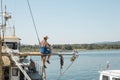 A man painting mast on his small boat Royalty Free Stock Photo