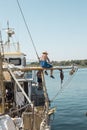 A man painting mast on his small boat Royalty Free Stock Photo