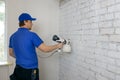 Man painting old brick wall in white color with paint sprayer Royalty Free Stock Photo