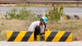 Man painting roadworks barriers on a road in Vietnam