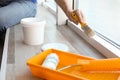 Man painting window frame at home, closeup