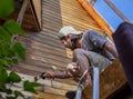 Man painting wooden wall of house outdoors Royalty Free Stock Photo