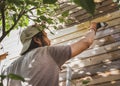 Man painting wooden wall of house outdoors Royalty Free Stock Photo