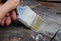 A man paints with a brush with gray paint. Painting the wooden surface Royalty Free Stock Photo