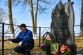 A man paints the fence on the monument to the dead Soviet soldiers in the second world war. The inscription on the monument in Royalty Free Stock Photo