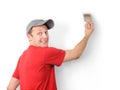 The man paints a withe wall with a brush