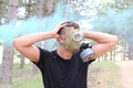 Man panicking in the forest with gas mask