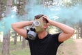 Man panicking in the forest with gas mask