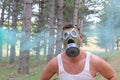 Man panicking in the forest with gas mask