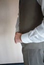 A man in pants and shirt buttoned a black leather trouser belt. Groom Dress up a belt with buckle. Businessman wear