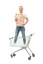 young caucasian man with paper bag standing in shopping cart