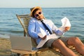 Busy man with papers talking by mobile phone on beach. Business trip Royalty Free Stock Photo