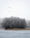 Man with parachute paragliding high in the air above hoarfrost t