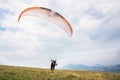 A man paraglider taking off from the edge of the mountain with fields in the background. Paragliding sports Royalty Free Stock Photo