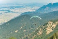 Man paragliding in the air between high mountains
