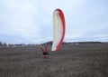 Man paramotorist and paramotor falling down on the ground in the field Royalty Free Stock Photo