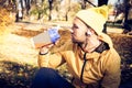 Man in park sitting drinking shake.