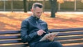 Man in a Park Using Big White Tablet PC