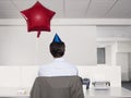 Man In Party Hat By Balloon Working In Office