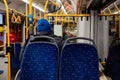 Man passenger dressed in a blue hooded jacket seats on a public bus. Through the bus windshield it can see the night city lights