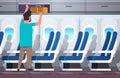 Man passenger putting luggage on top shelf travel vacation concept modern airplane board interior full length horizontal Royalty Free Stock Photo