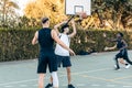 Man passing a ball during a basketball game between friends in an outdoor court