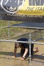 Man passing under the wires in a mud ground Royalty Free Stock Photo