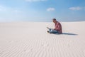 Man is passionate about work, with a laptop sits in desert Royalty Free Stock Photo