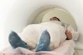 Man patient lying on a CT Scan bed. preparing for MRI magnetic resonance imaging in a hospital. in the hand of a man a