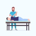 Man patient lying on massage table masseur therapist doing healing treatment massaging injured hand manual sport