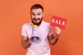 Man paying attention announcing big sale, holding loudspeaker, black Friday shopping, Royalty Free Stock Photo