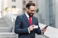 Man paying with credit card on smart phone outside. Mature businessman making order with credit card an phone while walking Royalty Free Stock Photo