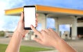 Man paying for refueling via smartphone at gas station, closeup. Device with empty screen Royalty Free Stock Photo
