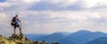 Man on peak of mountain. Emotional scene. Young man with backpack standing with raised hands on top of a mountain and enjoying mo Royalty Free Stock Photo