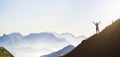 Man on peak of mountain. Emotional scene. Young man with backpack standing with raised hands on top of a mountain and enjoying mo Royalty Free Stock Photo