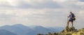 Man on peak of mountain. Emotional scene. Young man with backpack standing with raised hands on top of a mountain and enjoying mo Royalty Free Stock Photo