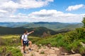 Man on peak of mountain. Emotional scene. Young man with backpack standing with raised hand on top of a mountain and Royalty Free Stock Photo